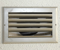 Closeup of a beige HVAC system vent.