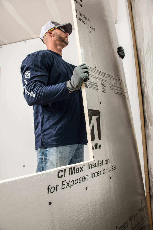 Contractor installing cut rigid foam board insulation.