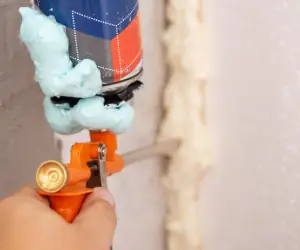 Man's hand holding air sealing gun.